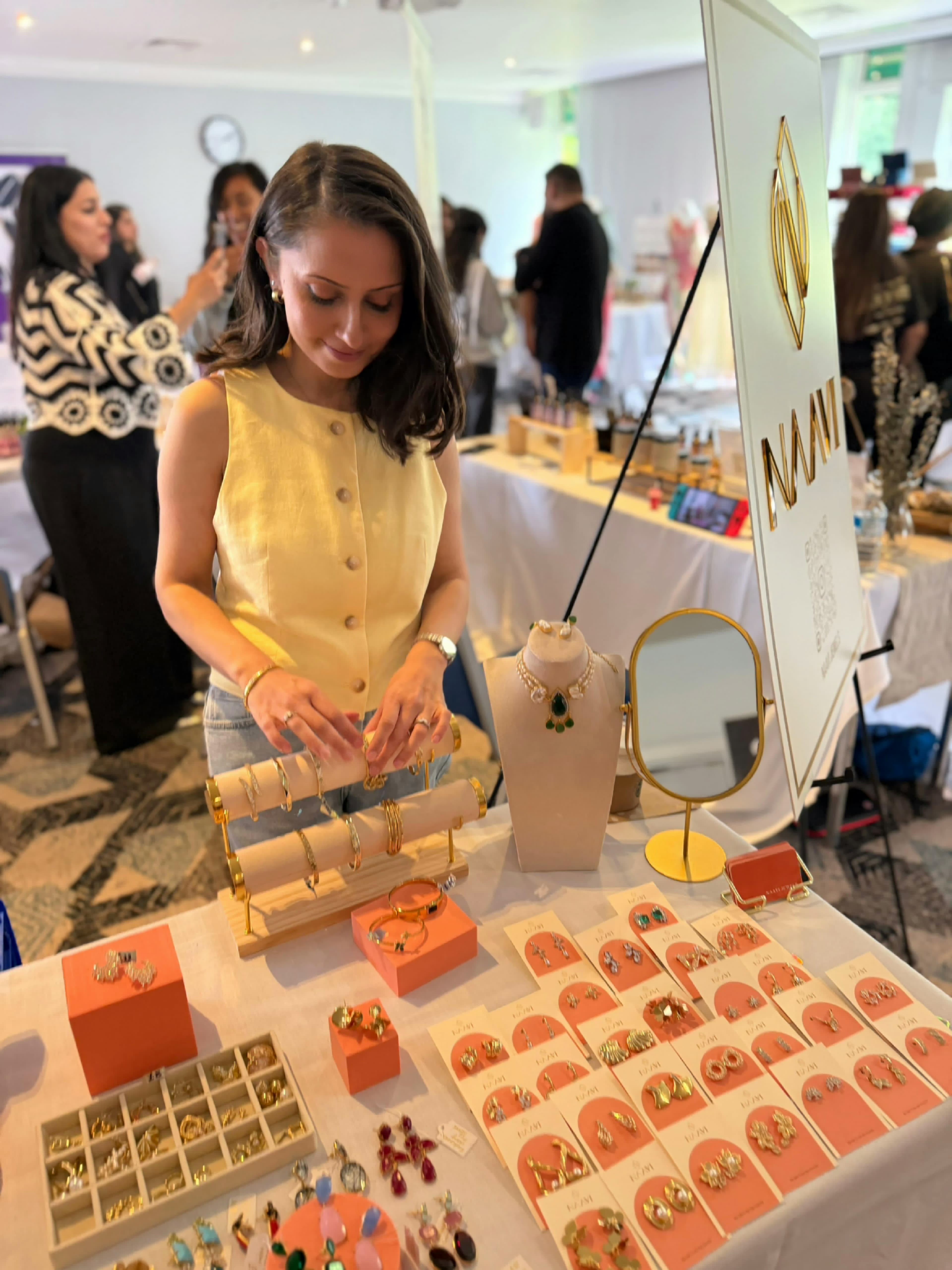 Asmita, founder of Naavi Jewels, at a market stall arranging her statement pieces